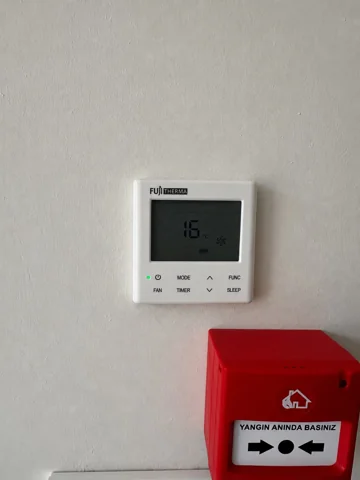 Besa Diş Kliniği duvarındaki klima kontrol paneli ve altındaki yangın ihbar butonu.