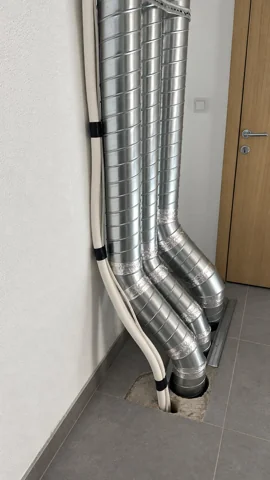 Besa Diş Kliniği duvar kenarında dirseklerle döşemeden geçen iki yuvarlak galvaniz hava kanalı.