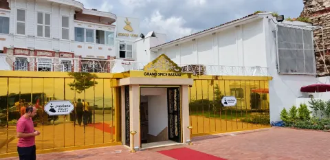 Sultanahmet Bazaar projesindeki altın renkli aynalı mağaza cephesi, giriş kapısı ve üzerindeki Grand Spice Bazaar tabelası.