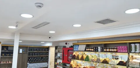 Sultanahmet Bazaar'daki ürün tezgâhı üzerinde görülen kare ve dikdörtgen tavan menfezleri ile aydınlatmalar.