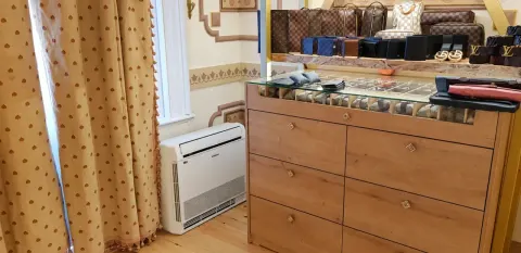 Sultanahmet Bazaar'da cam teşhir tezgâhı yanında ve pencere altında bulunan beyaz konsol tipi klima.